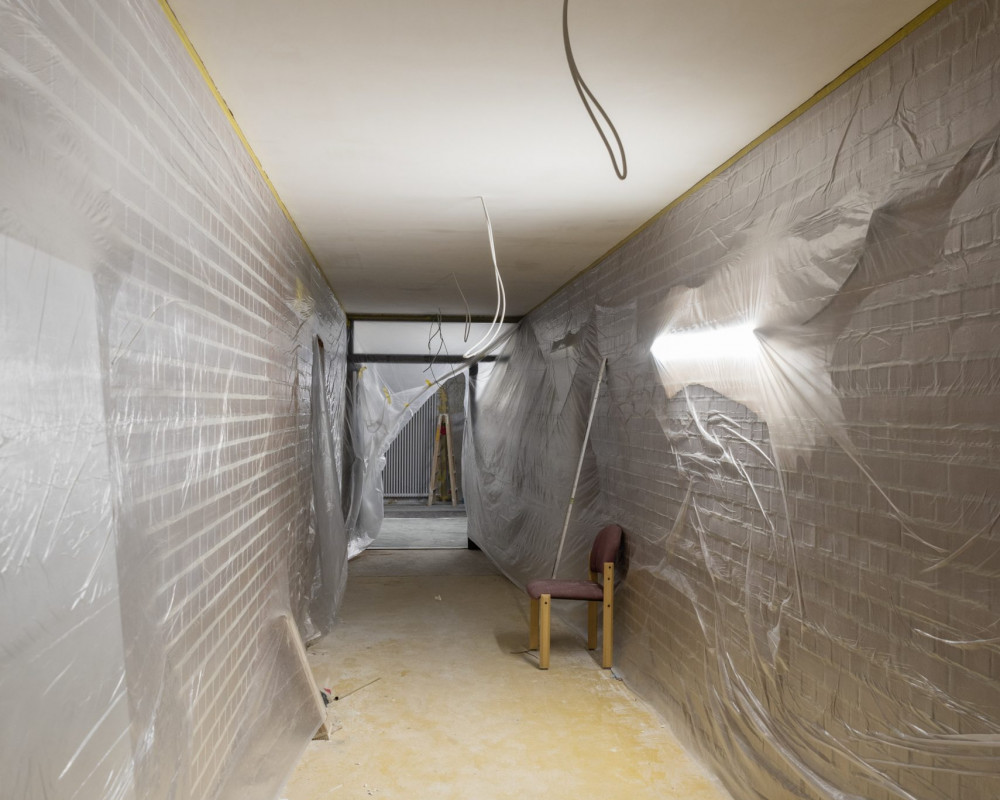 Die Fliesen sind nun fertig verlegt, die Türe wurde eingebaut, und der Maler hat alles für den Schlussanstrich vorbereitet.