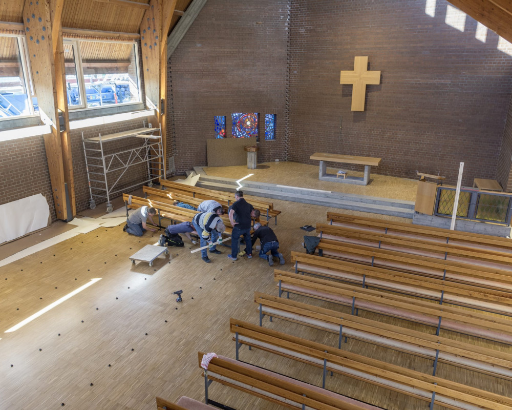 Die Kirchenbänke werden aufgestellt.