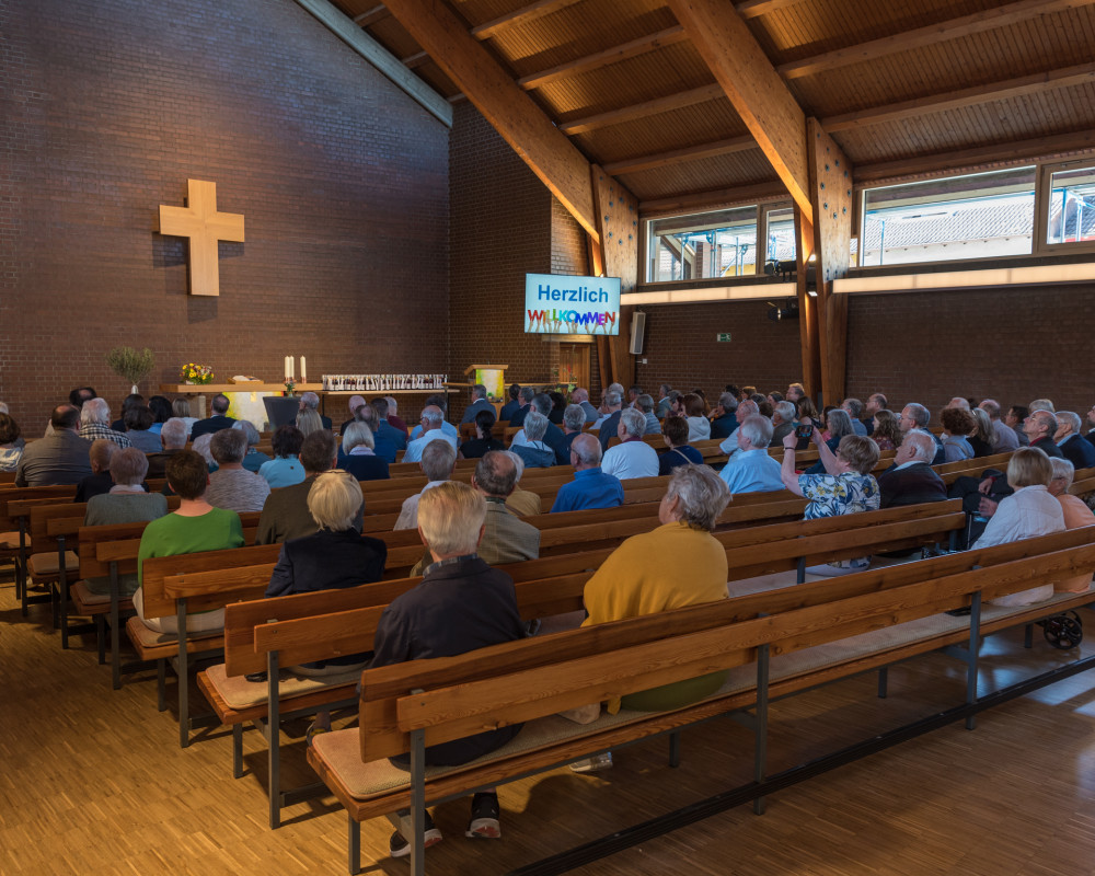 Kirche und Saal sind fast vollständig belegt.